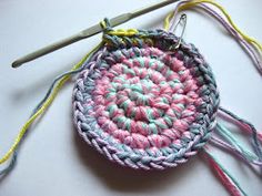 a crocheted basket with two yarns and a pair of scissors