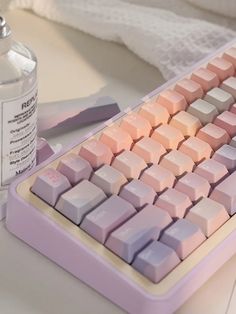 a computer keyboard sitting on top of a desk next to a bottle of water and scissors