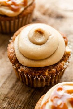 some cupcakes with icing and caramel on top