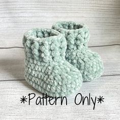 a pair of blue knitted baby booties sitting on top of a wooden floor