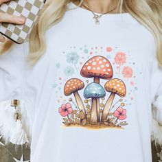 Mushroom Shirt, Magic Mushroom Shirt, Mushroom Tee, Nature lover Tee, Gardening Tee, Witchy Tee, Botanical Tee, Retro Tee, women's shirt Bella and Canvas 3001 Adult Unisex Tshirt Please be sure to check the sizing chart before you order to ensure the correct size is received. This Unisex T-Shirt feels soft & light with just the right amount of stretch. It's comfortable and flattering for all. It's sure to be your next favorite! Solid colors are 100% Airlume combed and ring-spun cotton Ash color is 99% combed and ring-spun cotton, 1% polyester Heather colors are 52% combed and ring-spun cotton, 48% polyester Athletic and Black Heather are 90% combed and ring-spun cotton, 10% polyester Pre-shrunk fabric Side-seamed construction Tear-away label Shoulder-to-shoulder taping No returns or cancel White Mushroom Print Top For Summer, White Mushroom Print Short Sleeve Top, White Short Sleeve Tops With Mushroom Print, Spring White Tops With Mushroom Print, White Short Sleeve Top With Mushroom Print, White Mushroom Print Top For Spring, Spring White Top With Mushroom Print, Casual White Shirt With Mushroom Print, White Crew Neck Top With Mushroom Print