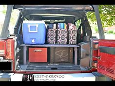 the back end of a red truck filled with luggage