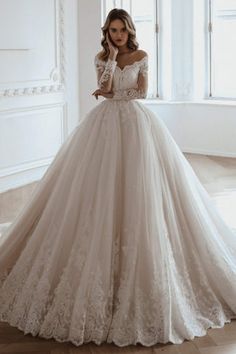 a woman in a wedding dress posing for the camera with her hand on her face