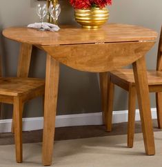 a wooden table with two chairs and a potted plant