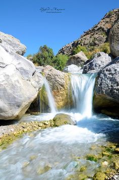 there is a small waterfall in the middle of some rocks