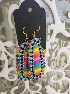 Another fun pair of earrings featuring a rainbow Cobochon made out of resin.  I got a little more creative with these however, and they turned out amazing!   They are edged in rainbow crystals, and backed woth a faux leather backing that has black glitter. Earwires are hypo allergenic as always, and made from surgical steel. Rainbow Crystal Drop Earrings For Gift, Unique Rainbow Earrings, Handmade Multicolor Crystal Earrings For Party, Handmade Rainbow Teardrop Jewelry, Unique Rainbow Earrings With Ear Wire, Unique Handmade Rainbow Earrings, Handmade Rainbow Beaded Earrings For Party, Handmade Rainbow Earrings For Party, Rainbow Party Earrings With Colorful Beads