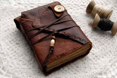 a brown leather journal sitting on top of a white table