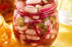 several jars filled with fruit and veggies sitting on top of a wooden table