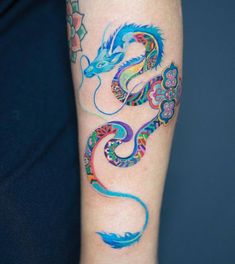 a colorful dragon tattoo on the arm