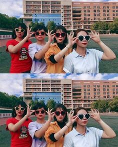 two people wearing sunglasses are standing in front of a building with their hands up to the camera