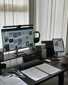 a computer monitor sitting on top of a desk next to a keyboard and mouse in front of a window