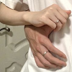 a man and woman wearing wedding rings holding each other's hands in front of a mirror