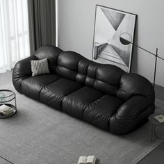 a black leather couch sitting on top of a gray rug