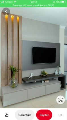 a flat screen tv mounted to the side of a wall next to a vase with flowers