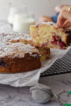 a person is holding a piece of cake with powdered sugar on top and the other half has been eaten