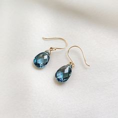 These stunning earrings are set in 14K Solid Yellow Gold with Natural London Blue Topaz with utmost precision. It is an unique gemstone earring pair for nearly every occasion and is completely hassle-free jewelry. ITEM DETAILS: * Gem: London Blue Topaz * Gem Size: 8x12 mm * Gem Shape: Teardrop * Gem Weight: 7.39 carats * Gold Purity: 14KT * Gold Weight: 0.43 gram * Total Weight of the Earrings: 1.91 gram The Gold purity is guaranteed and it comes with authentic 14KT gold hallmark. Since my items are handmade, they are absolutely nickel and lead free. CUSTOMIZATION: * Gemstone customization is available and the it can be substituted with a gem of your choice. Kindly message me for the same. PACKAGING * The Earrings comes with layers of safe and secure wrapping along with Free handmade jewel Blue Briolette Earrings For Formal Occasions, Elegant Blue Topaz Teardrop Earrings, Elegant Teardrop Blue Topaz Earrings, Blue Briolette Earrings Fine Jewelry, Fine Jewelry Blue Topaz Drop Earrings, Blue Topaz Drop Earrings Fine Jewelry, Elegant Blue Faceted Crystal Earrings, Elegant Blue Topaz Briolette Earrings, Elegant Blue Topaz Earrings With Ear Wire