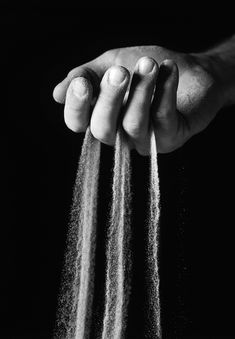 a person holding sand in their hands