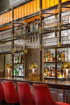 a bar with red chairs and wine glasses