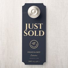 a door hanger that says just sold on it with a bottle opener attached to it