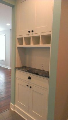 an empty kitchen with white cabinets and granite counter tops in the center of the room