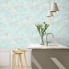 a kitchen with two stools next to a sink and counter top in front of a wallpapered background