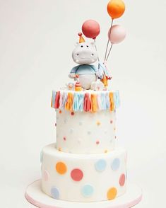 a birthday cake decorated with an animal and balloons