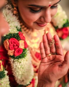 a woman is holding her hands together in front of the camera and wearing a gold ring