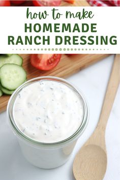 a jar filled with ranch dressing sitting on top of a cutting board next to cucumbers