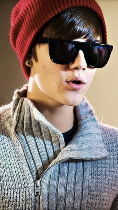 a young man wearing sunglasses and a knitted hat