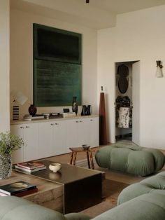 a living room filled with furniture and a green chalkboard on the wall behind it