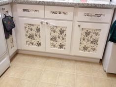 a kitchen with white cabinets and tile flooring