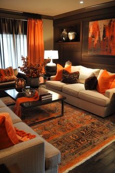 a living room filled with lots of furniture and orange pillows on top of it's couches