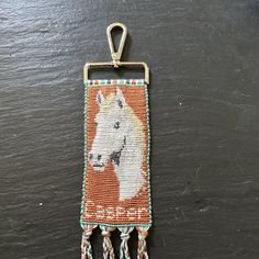 a small beaded key chain with a horse on it's front and sides