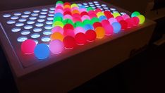 an illuminated table with many different colored balls on it