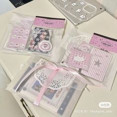 three clear bags with pink and white designs on them sitting on a table next to scissors