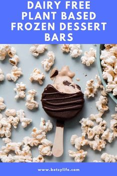 a blue plate topped with chocolate covered marshmallows next to a bowl of popcorn