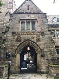 an old stone building with a clock on it's face and gated entrance