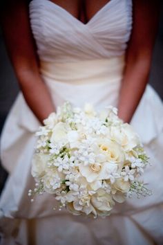 a bridal holding a bouquet of white flowers