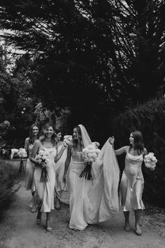 black and white photograph of bridesmaids walking down the road with their bouquets