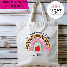 a tote bag with the words teaching is a work of heart and an apple on it