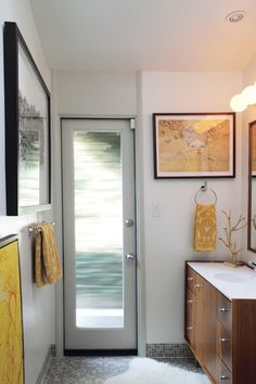 a bathroom with a sink, mirror and two pictures on the wall next to it