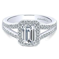 an emerald - cut diamond engagement ring with pave set diamonds on the shoulders and sides