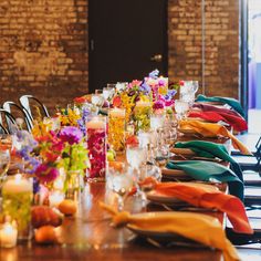 a long table is set up with colorful flowers and candles