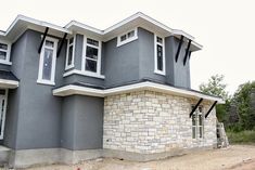 a gray house with white trim and windows