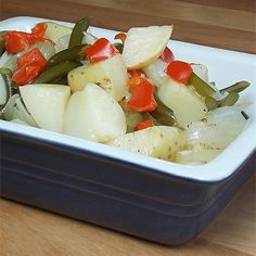 a bowl filled with vegetables sitting on top of a wooden table