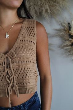 Elevate your wardrobe with our chic crochet vest top, designed for effortless style and comfort. This sleeveless piece features a playful tie-front detail and a flattering plunging V-neckline, adding a touch of sophistication to your look. The delicate crochet pattern adds texture and a hint of bohemian flair, perfect for layering or wearing solo. Ideal for warm weather or a sun-soaked getaway, this vest top effortlessly combines fashion and function. for reference Karlee is 5’8 and wearing a si