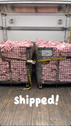 the back of a truck filled with crates and wrapped in pink tissue paper that says, shipped