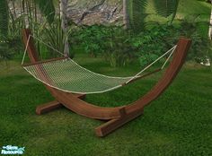 a wooden hammock sitting on top of a lush green field