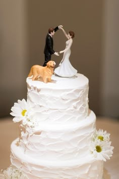 a wedding cake with a bride and groom figurines on top