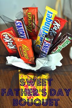 an arrangement of candy bars in a vase on a table